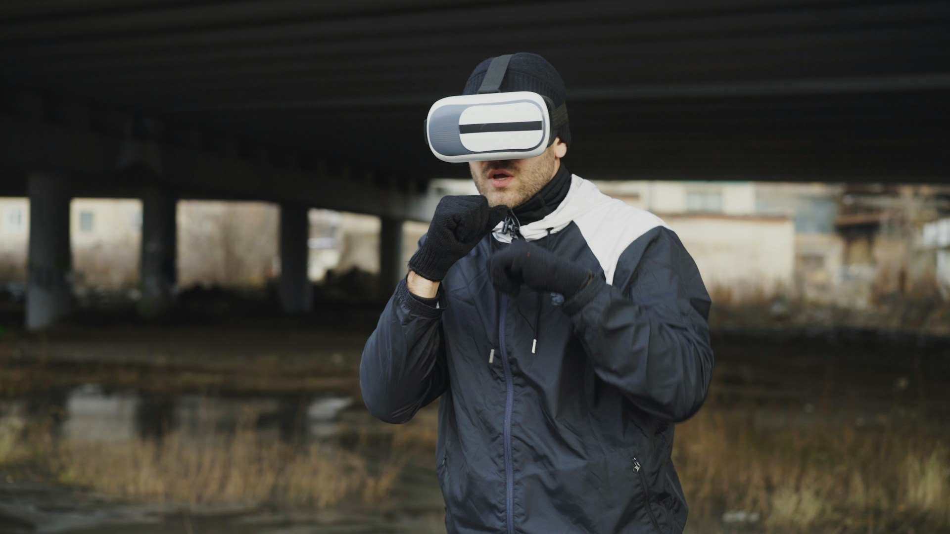 Man in vr headset boxing outdoors under a bridge