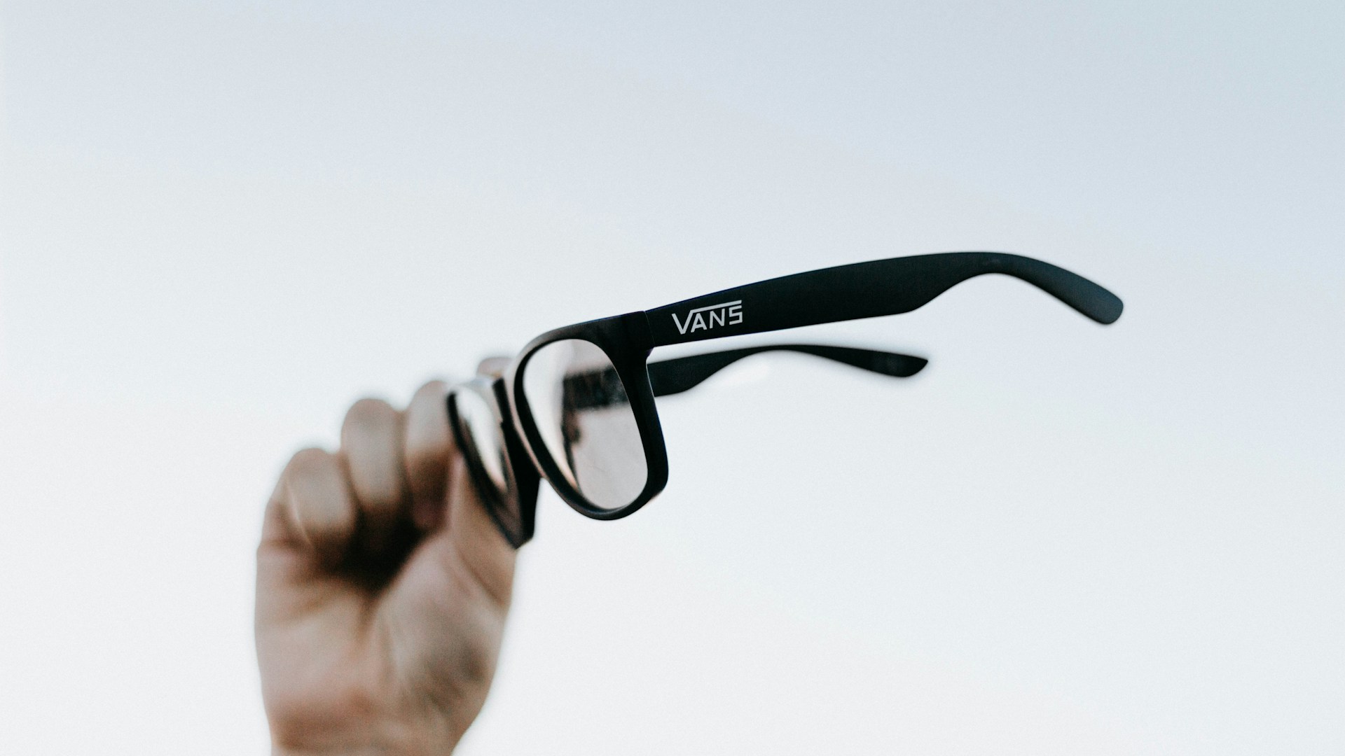 a hand holding up a pair of glasses