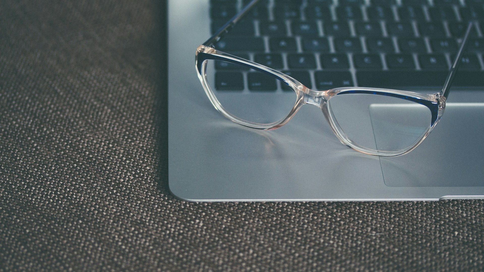 clear eyeglasses with black frames on laptop