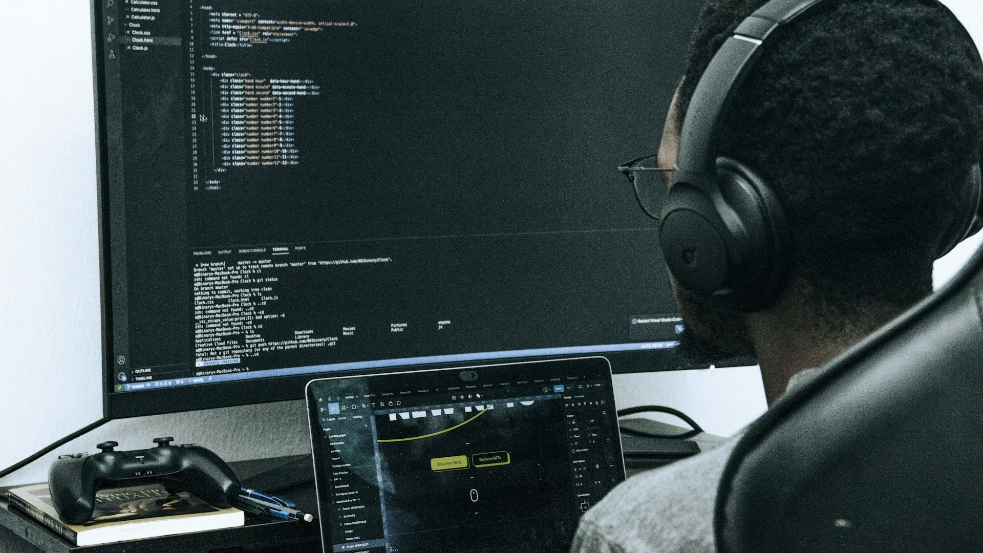 A man sitting in front of a computer wearing headphones